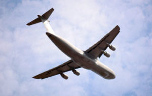 plano contra-picado de avião de carga a efectuar transporte aéreo de mercadorias