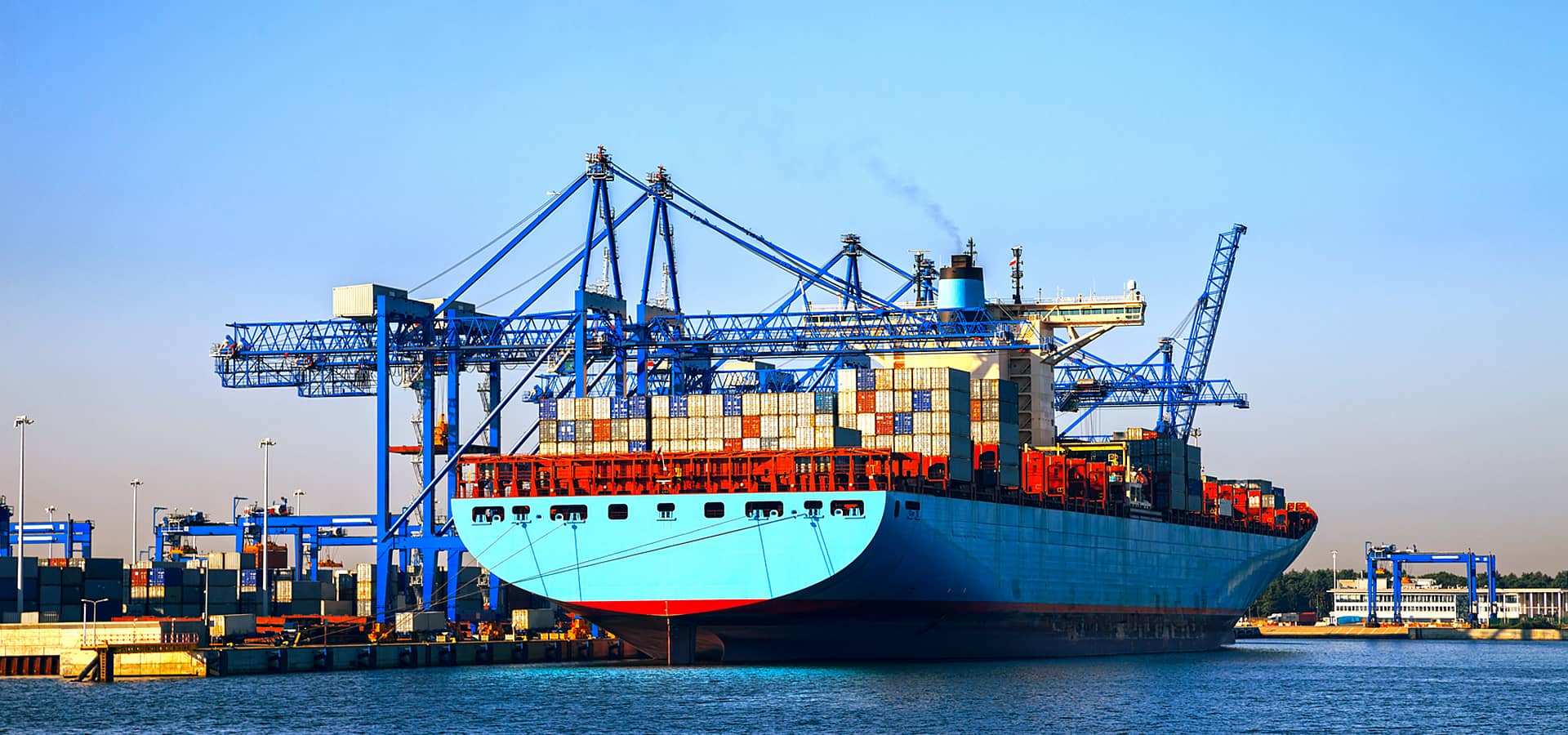 Barco no porto, a carregar para sair em transporte marítimo